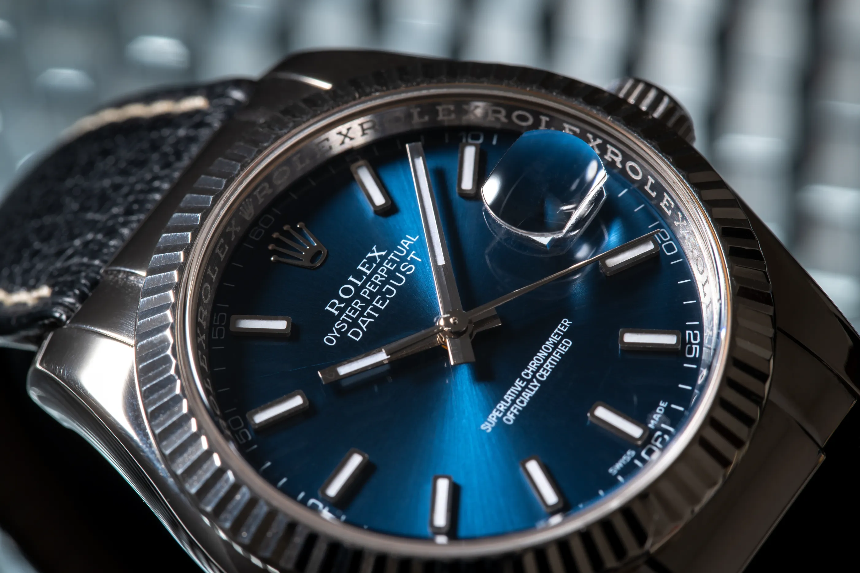 Primer plano de un reloj Rolex Oyster Perpetual Datejust con esfera azul y lupa Cyclops.